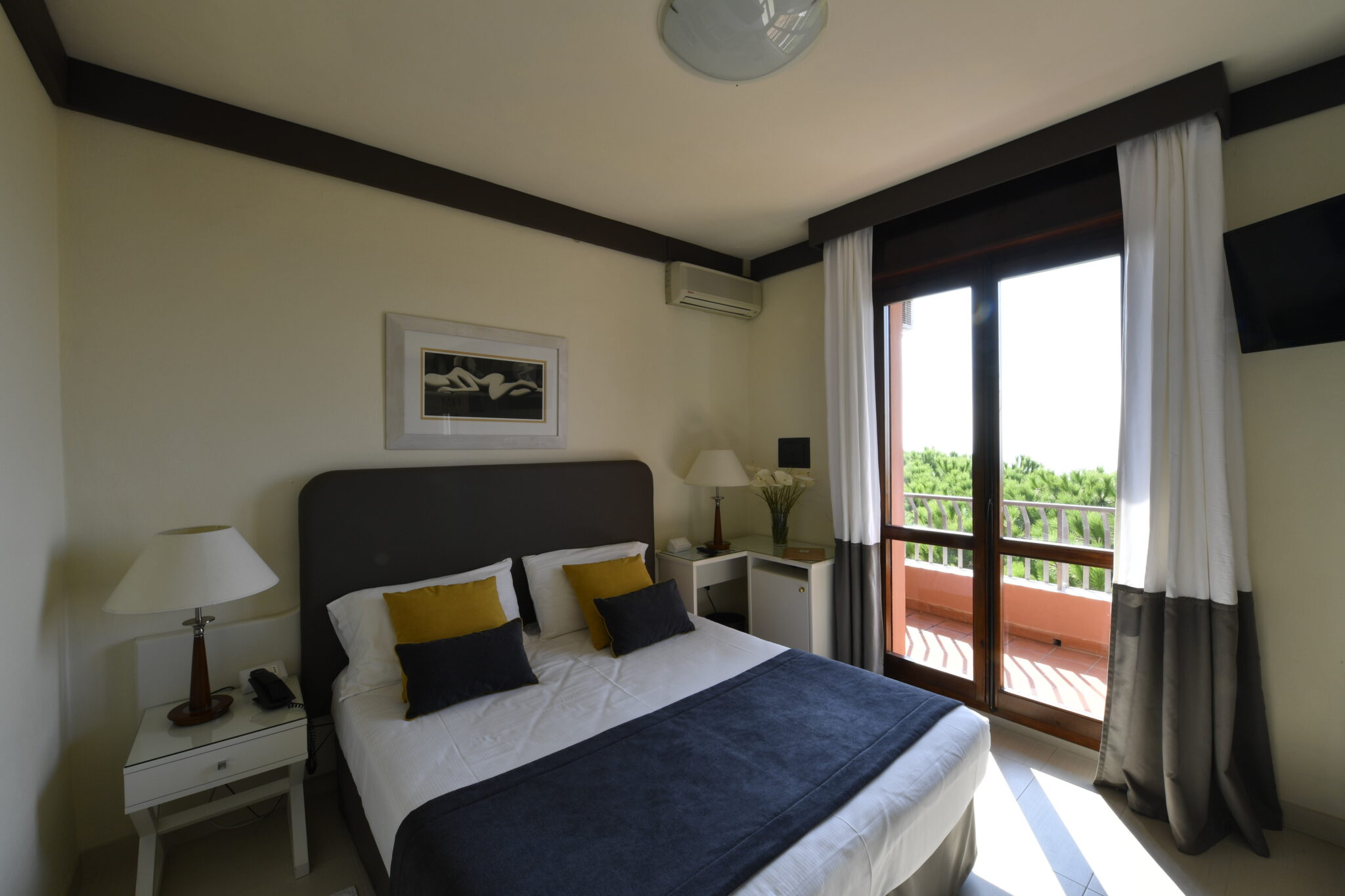 Letto matrimoniale della camera premium con balcone fronte mare